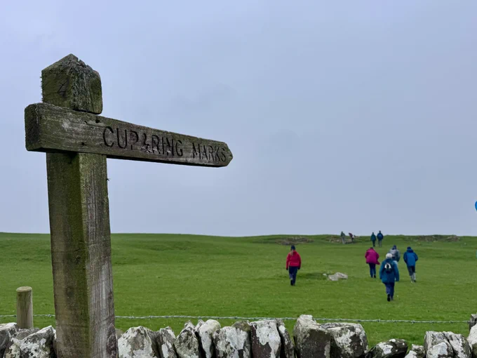 Participants of the Kirkcudbright Rock Art Workshop walking up to High Banks cup & ring marks