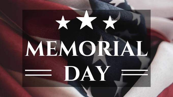 Three white stars and white text reading "Memorial Day"  superimposed over an image of a folded American flag