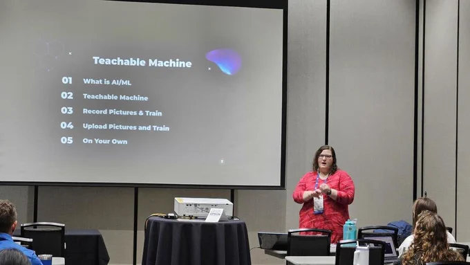 high school teacher in front of a large screen presenting teachable machine to audience