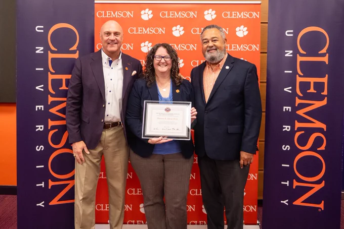 President Clements and Max Allen posing for a photo with a President’s Leadership Institute graduate.