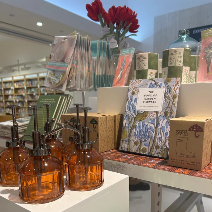 A photo of a gardening-themed product shop display with crotched flowers, plant misters and décor.