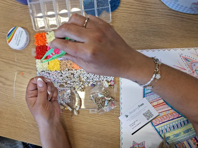 a pair of hands carefully creating a bracelet