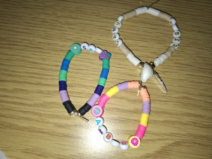 three hand-made bracelets of different colours and beads