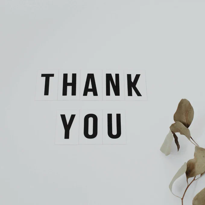 Thank You in black writing on pale background.  Leaves pattern.