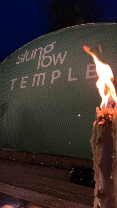 A large candle at the edge of the outdoor stage space at Temple