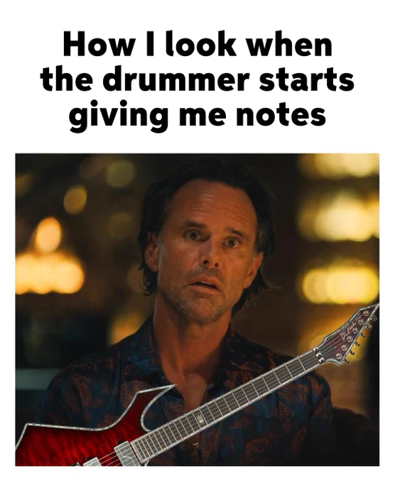 A person looks surprised while holding a guitar, with a caption above reading "How I look when the drummer starts giving me notes.