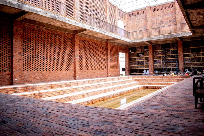 Red brick architectural structure with open roof

