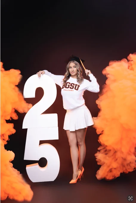 A person in a graduation cap and Bowling Green State University Falcons sweatshirt stands between large numerical figures "2" and "5", surrounded by orange smoke on a dark background.