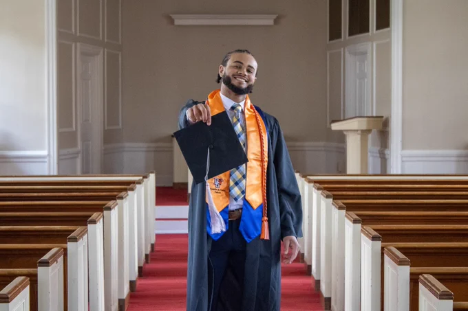 BGSU grad poses with grad cap in Prout Chapel