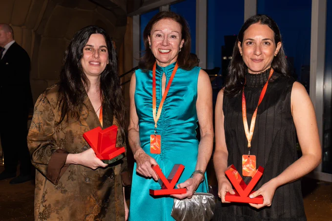 Selva Aparicio, Marianne Bronner, and Maayan Levy hold their awards towards the screen