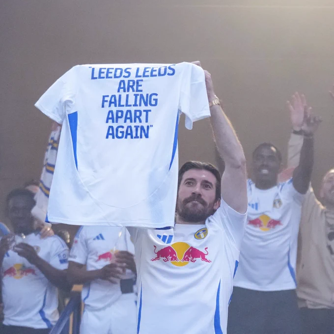Joe Rothwell holds up a shirt that says “Leeds, Leeds are falling apart again”
