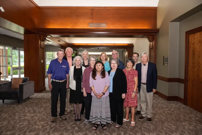 A group of people posing for a photo indoors.