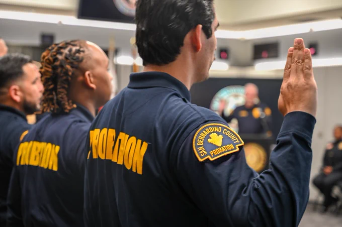 Officers raising their right hands as they take their oath during a swearing-in ceremony.