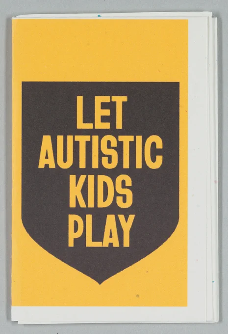 A yellow piece of paper showing a shield with "Let Autistic kids play" written on it