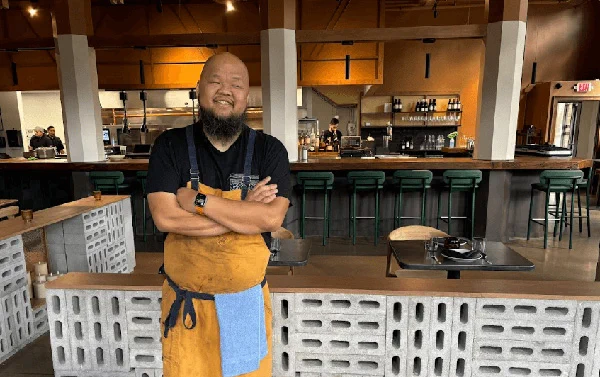 Chef Yia Vang stands proudly in the dining room of his Minneapolis restaurant, Vinai.