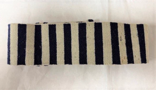Colour photograph of a textile striped armband in white and blue