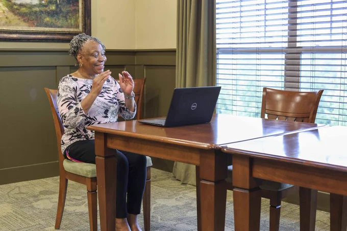 Woman does tai chi exercise class at her computer