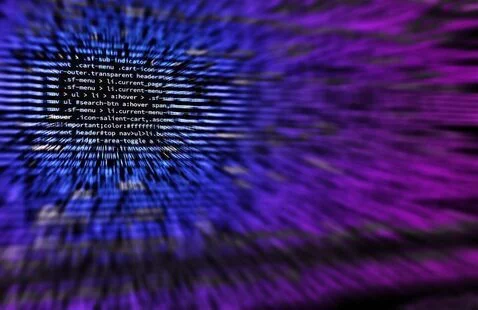 Lines of CSS code in sharp focus at the center, surrounded by a radial blur of blue and purple.