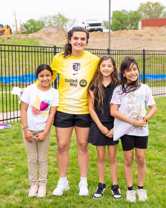 Laurel Ivory smiling and posing with Girls on the Run participants