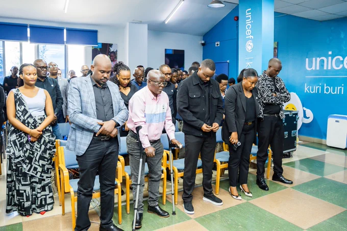 A group of people in a reverent stance while praying.