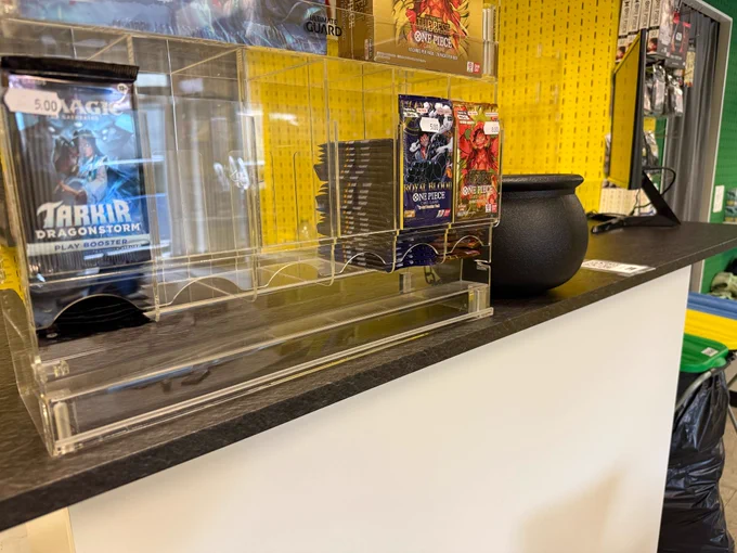 Picture of the sales counter inside the CastleGames store with various trading card products in the foreground.