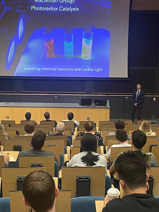 Full-color image of Taylor Auditorium with seated students and grad student upfront presenting.
