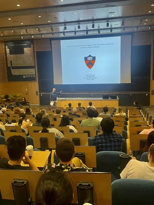 Full-color image of audience at Taylor Auditorium and P.I. upfront introducing his advisee.