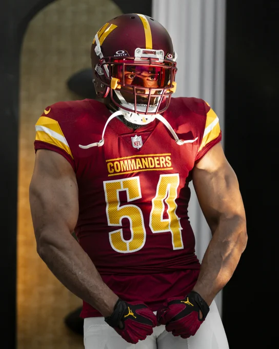 Photo of Bobby Wagner. He is flexing and wearing a burgundy helmet, burgundy jersey and white pants.