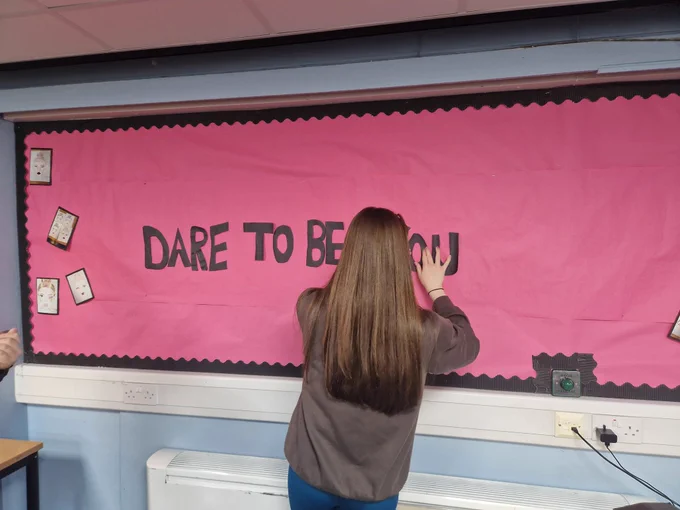 A young girl creating a display for the Dare To Be You Project