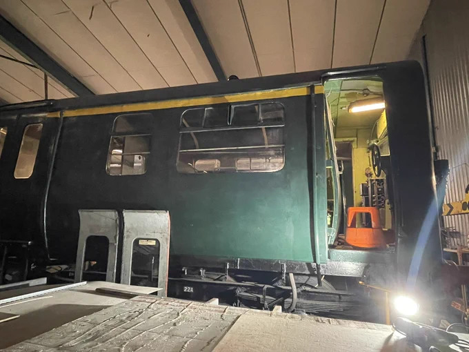 Side view of 502 coach painted green with “1st class” yellow stripe