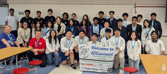 Several dozen students are posing in a school cafeteria with a sign being held in the front row. The sign is titled, "Welcome to ATConnect!"
