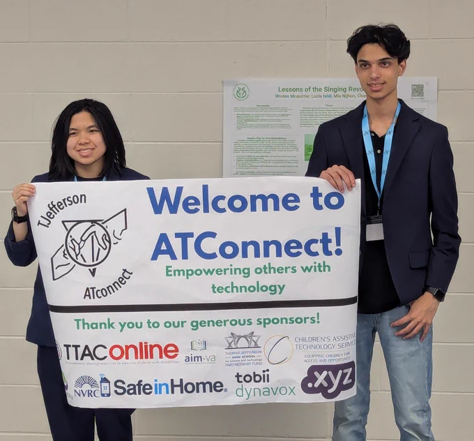 A female and male student are holding a signed titled, "Welcome to ATConnect!"