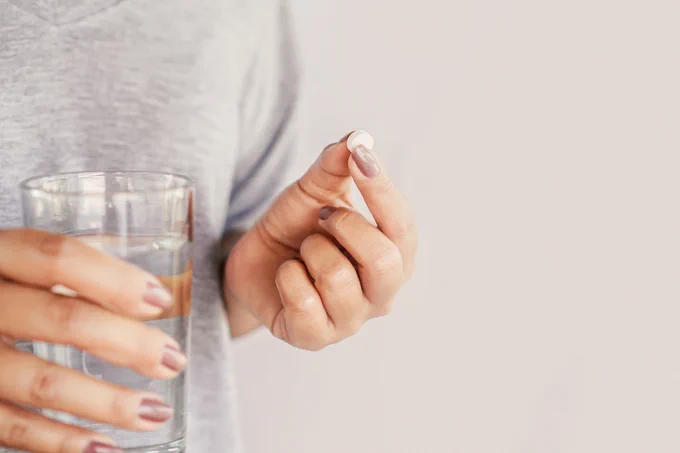 An image of a hand holding a pill