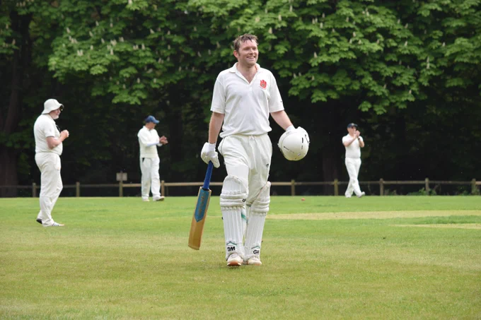 Harry Low smiles while walking off after century