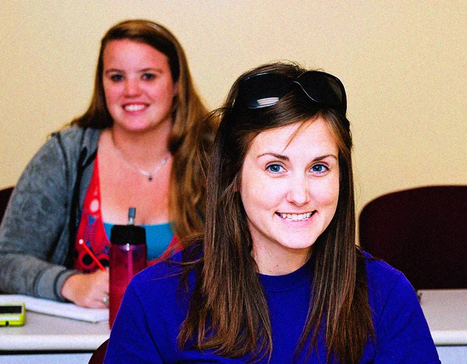 Two students smile in class