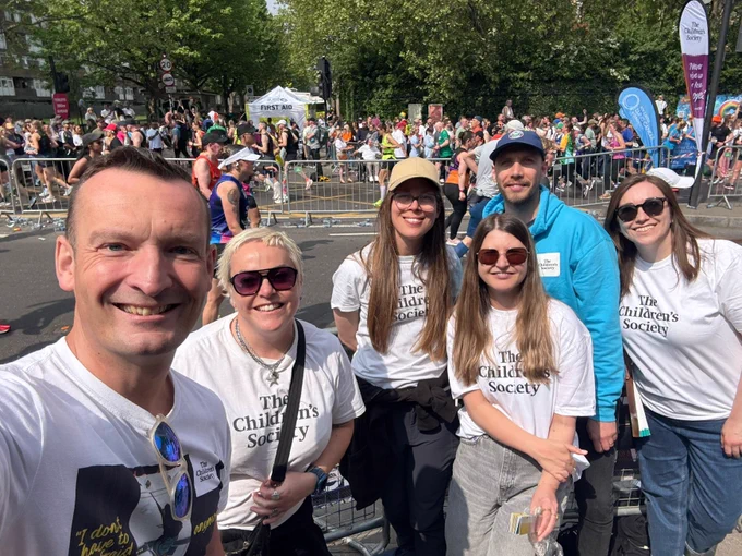 Group of The Children's Society staff and volunteers cheering on marathon runners