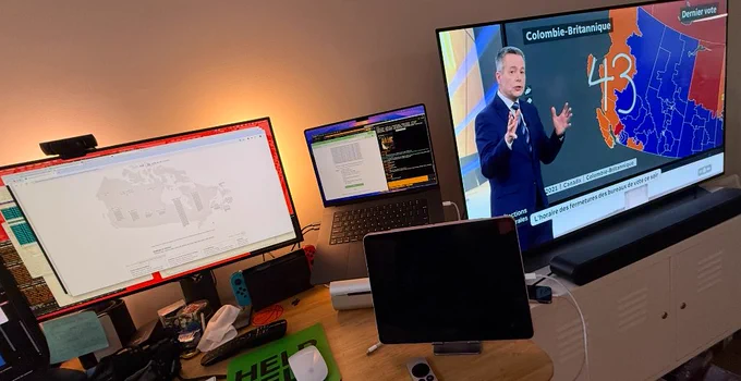 Un écran d'ordinateur et une télévision montrant les résultats de l'élection canadienne