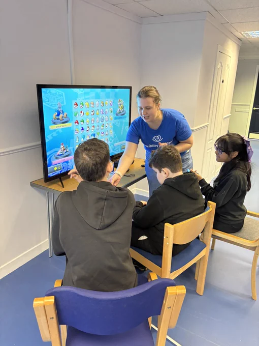 August helping 3 pupils to play Super Mario