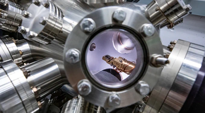 A 2D material sample that is held within an ultrahigh vacuum, low-temperature scanning probe microscope.