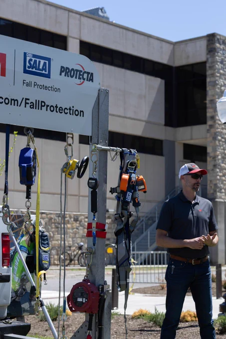 Photo of a guy talking about safety with safety equipment next to him. 
