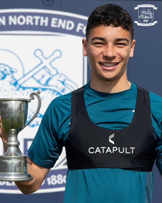Theo Carroll smiling and holding a trophy.