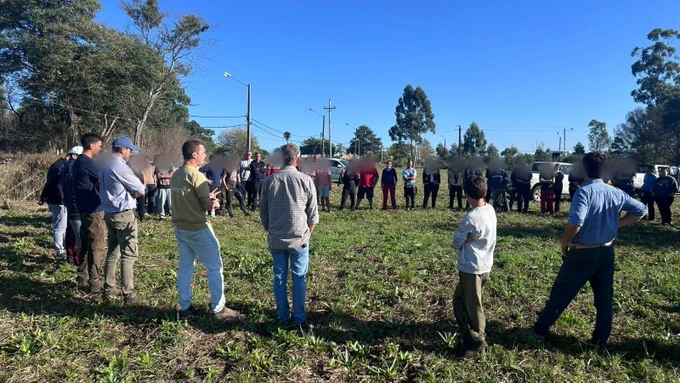 Ronda de adolescentes y voluntarios sobre césped y arboles al fondo 