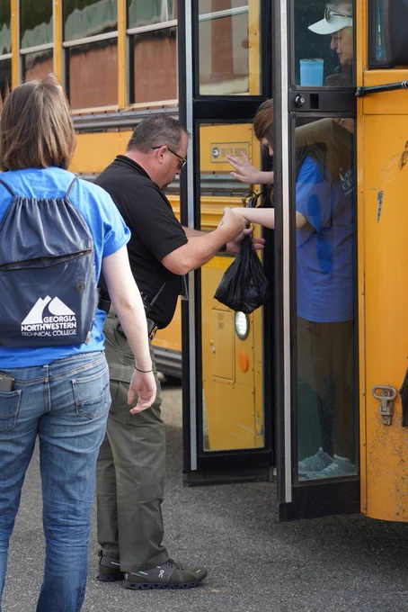 Chief Billy Henson helping a student off a school bus
