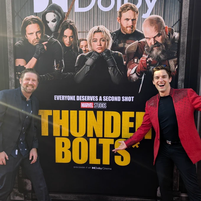 MatPat and #BlameJason on the red carpet of the Thunderbolts Premiere in front of a giant poster of the main characters of the movie.