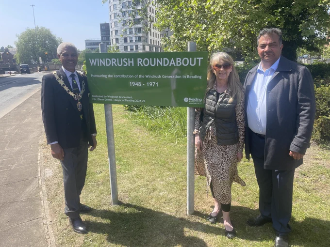 The Mayor of Reading Cllr Glenn Dennis, Cllr Karen Rowland and Cllr Mohammed Ayub unveiling the Windrush Roundabout sign. The text on the sign reads: Windrush Roundabout. Honouring the contribution of the Windrush Generation in Reading. 1948-1971. Dedicated by Windrush descendant: Cllr Glenn Dennis - Mayor of Reading 2024-25