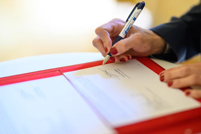 Une femme signe un document.