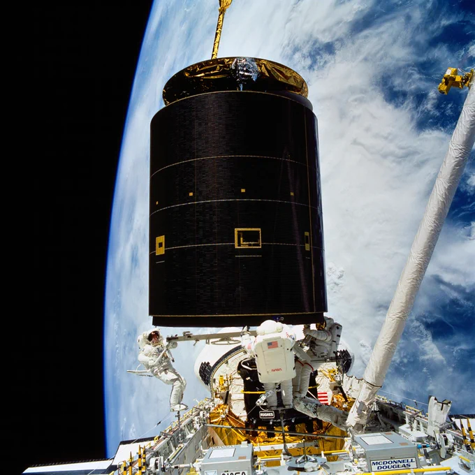 Backdropped by Earth's limb, three astronauts grapple the Intelsat VI satellite from space shuttle Endeavour's cargo bay. A fellow crew member took this photo from inside Endeavour's cabin. Left to right, astronauts Richard J. Hieb, Thomas D. Akers and Pierre J. Thuot, cooperate on the effort to attach a specially designed grapple bar underneath the satellite. 
