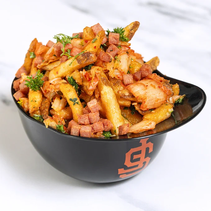 Plastic replica Giants batting helmet filled with French fries, kimchi, fried spam, garlic, parsley, salt and pepper.
