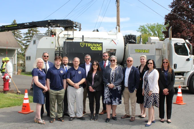 EFC team members pose in front of a construction vehicle on a city street 
