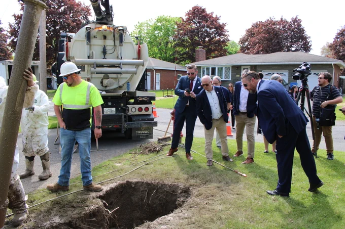 EFC team members look at an excavated lead service line at a residence 